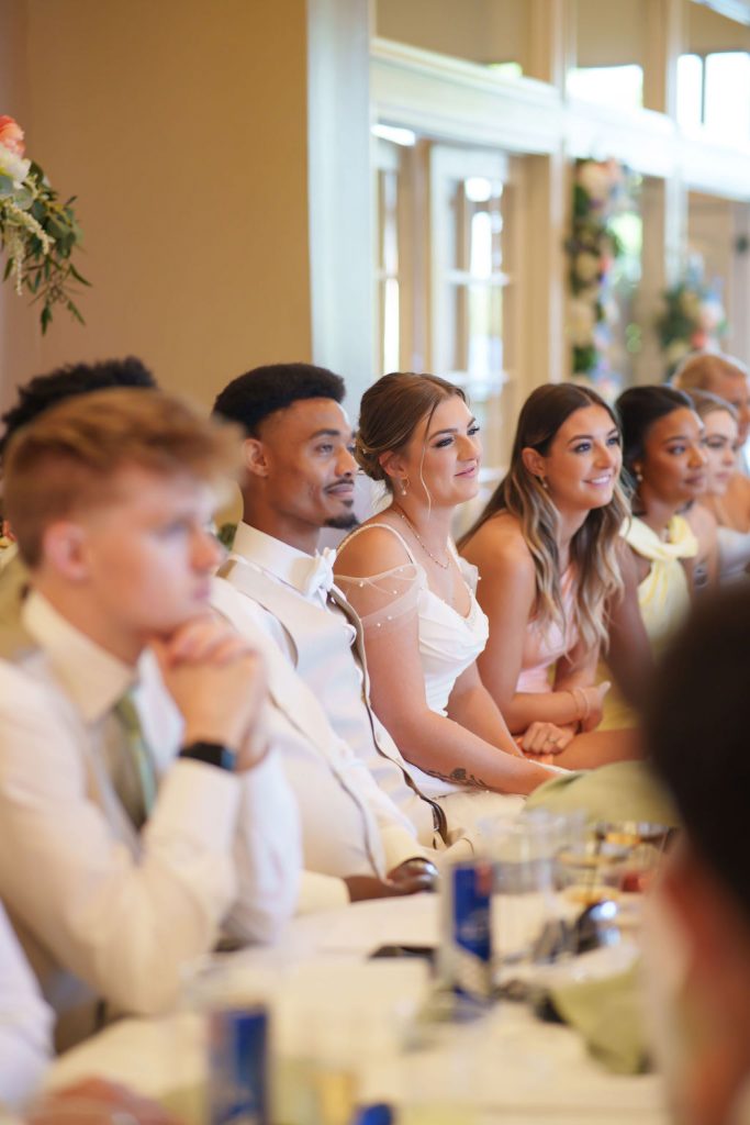 Emotional bride, bride and groom, listening to speeches, focal point on bride tearing up