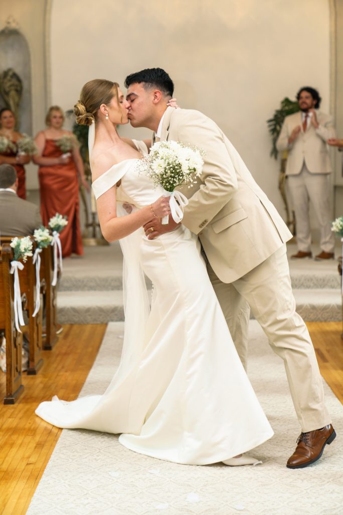 Couple dipping in aisle, dip kiss, walking down aisle as bride and groom